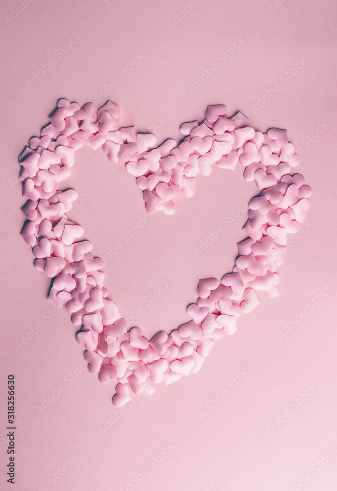 Pink heart confetti on pink background. Festive holiday pastel backdrop. Flat lay. Top view. Copy space
