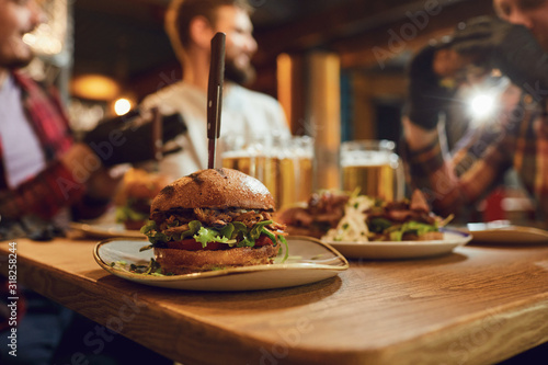 Foto Burger with beer on the table in a bar pub.