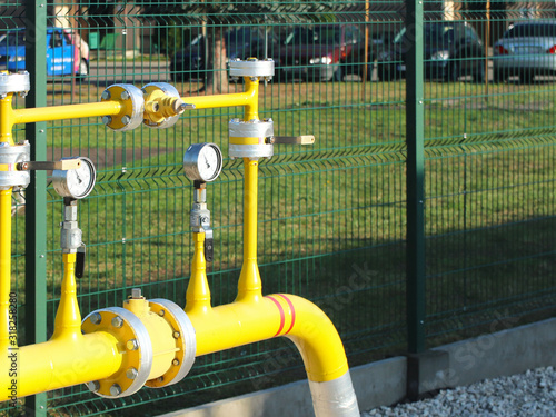 Element gas line high and medium pressure. Yellow transport pipes on the surface of the fence. Regulatory supply system for natural compressed fuel. Access overlap valves and pressure sensors photo