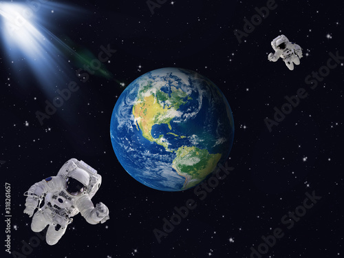 Two astronauts in outer space with Planet Earth. Elements of this image furnished by NASA.