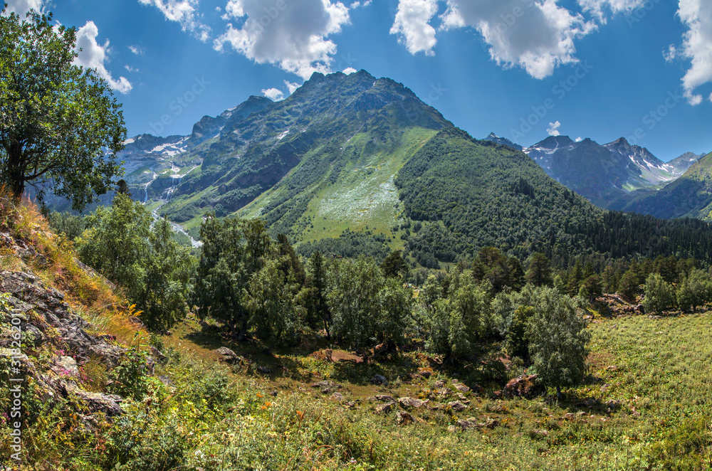 Valley in the Caucasus Mountains, green slopes and blue sky