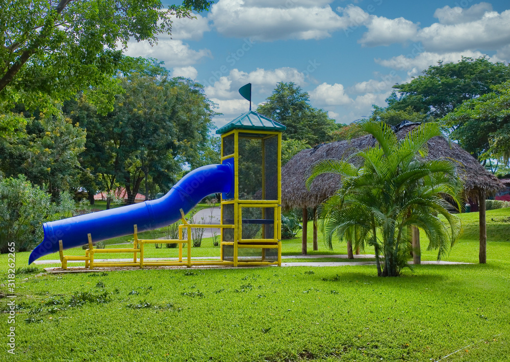 A park playground with a blue sliding board. A park playground with a blue sliding board.