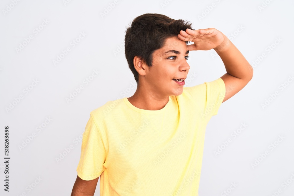 Handsome teenager boy standing over white isolated background very happy and smiling looking far away with hand over head. Searching concept. Handsome teenager boy standing over white isolated background very happy and smiling looking far away with hand over head. Searching concept.