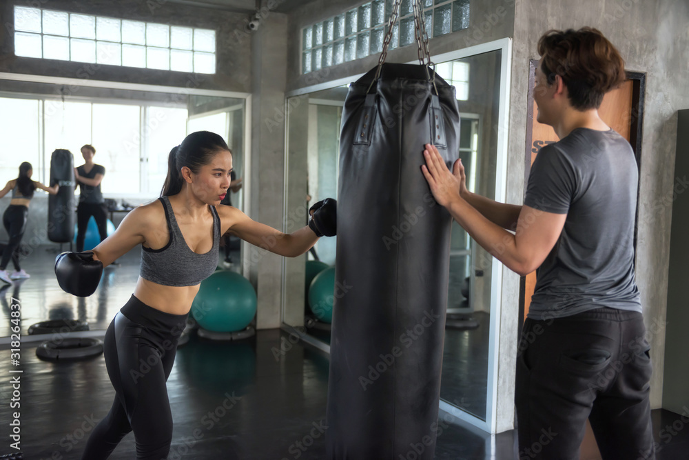Boxing woman training with coach in gym