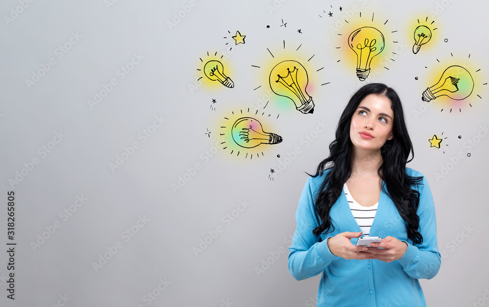 Idea light bulbs with thoughtful young woman holding a smartphone Idea light bulbs with thoughtful young woman holding a smartphone