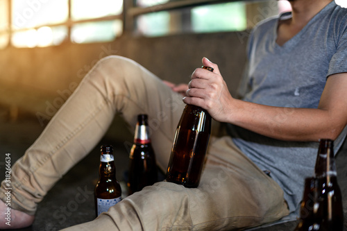 Portrait of a drunken man holding a bottle in front of him