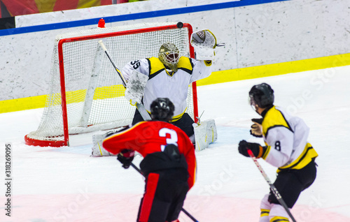 Photography Ice hockey player shoots the puck against the goalie