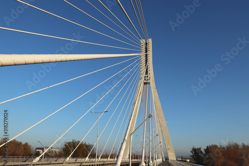 Rzeszow, Poland - 9 9 2018: Suspended road bridge across the Wislok River. Metal construction technological structure. Modern architecture. A white cross on a blue background is a symbol of the city photo