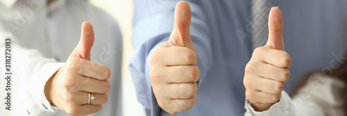 Fotografia Focus on tender female and male hands showing big thumb up and posing at modern workplace
