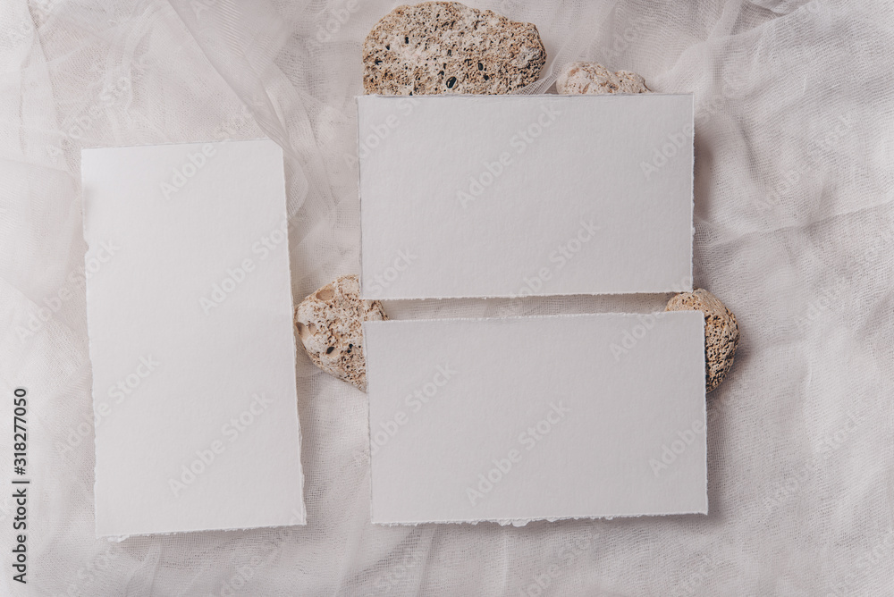 Wedding invitation mockup with paper, stone, green branch on white textile background. Top view, flat lay. Wedding stationary. Perfect for presentation of your wedding invitation, menu, greeting cards Wedding invitation mockup with paper, stone, green branch on white textile background. Top view, flat lay. Wedding stationary. Perfect for presentation of your wedding invitation, menu, greeting cards