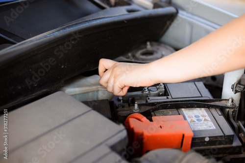 Young girl tries to repair broken car by herself, opening some tank with oil © Vitalii
