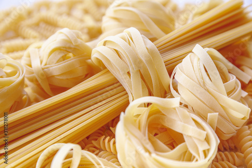 Italian rolled raw tagliatelle and spagetti pasta as background texture. photo