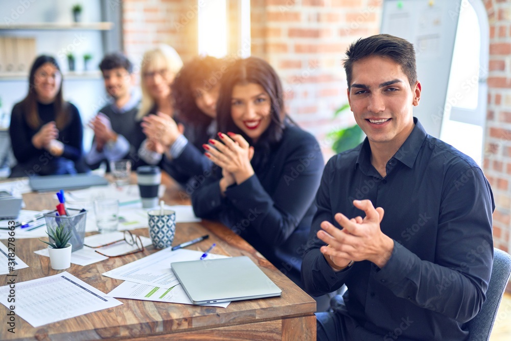 Group of business workers smiling happy and confident. Working together with smile on face looking at the camera applauding at the office Group of business workers smiling happy and confident. Working together with smile on face looking at the camera applauding at the office