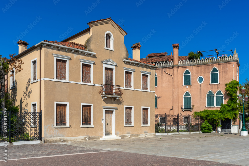 Venice, Italy. View of Venice. Beautiful embankment. Venetian old colorful building palazzo against blue sky. Authentic architecture. Travel Tourism Vacation in Europe concept.