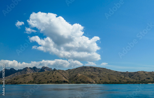 Wallpaper Mural A view on idyllic island in Komodo National Park, Indonesia. There are few clouds above the island. Calm and clear surface of the sea. Island hoping. Perfect day for sailing Torontodigital.ca