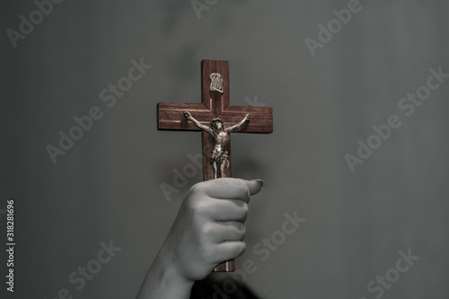 A female hand holds a crucifix. Crucifix in the hand. The concept of exorcism