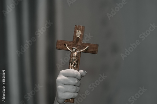 A female hand holds a Crucifix. Crucifix in the hand. The concept of exorcism