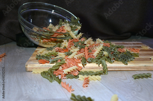 Multi-colored pasta on a wooden board. Food.