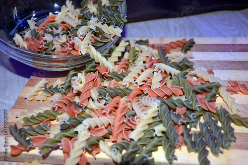 Multi-colored pasta on a wooden board. Food.