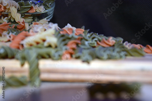 Multi-colored pasta on a wooden board. Food.
