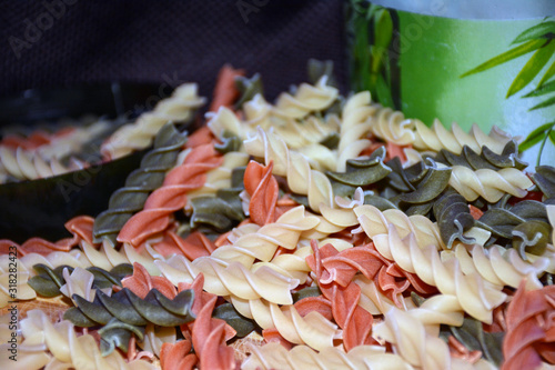 Multi-colored pasta on a wooden board. Food.
