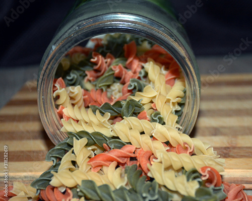 Multi-colored pasta on a wooden board. Food.