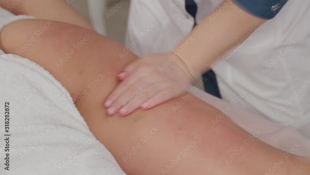 Female massage therapist doing massage over the entire length of the legs of a young girl. Female massage therapist doing massage over the entire length of the legs of a young girl.