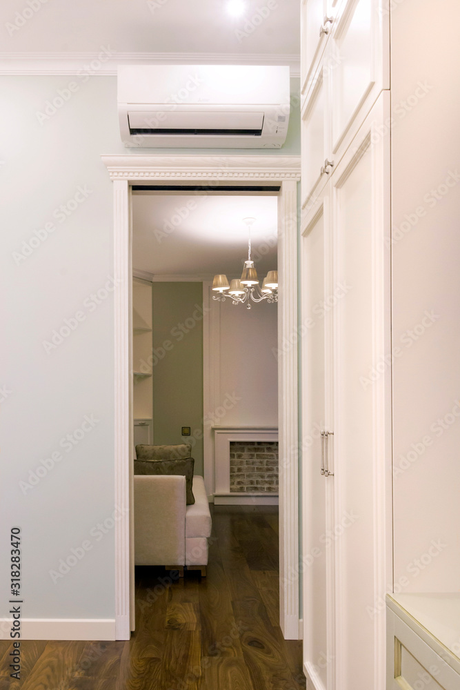 View of the air conditioning above the door in the room. Living room with fireplace behind the door View of the air conditioning above the door in the room. Living room with fireplace behind the door