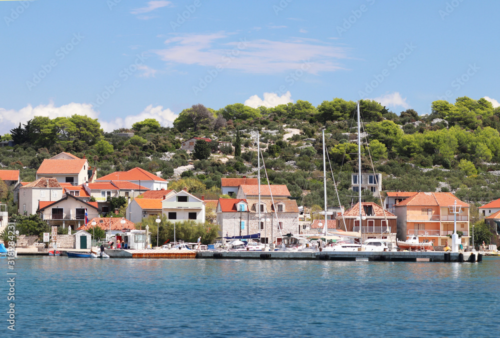 Panorama of a yacht marina in the town of Jezera in Croatia in the Dalmatia region. The ships moored in the port of a quiet fishing town in a sunny, clear day. Tourist marine business. Murter island