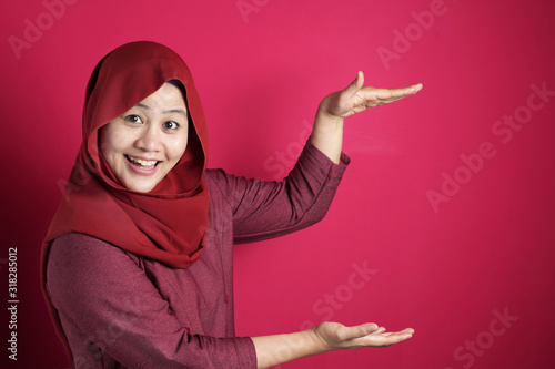 Muslim Lady Presenting Something Between Her Hands with Copy Space