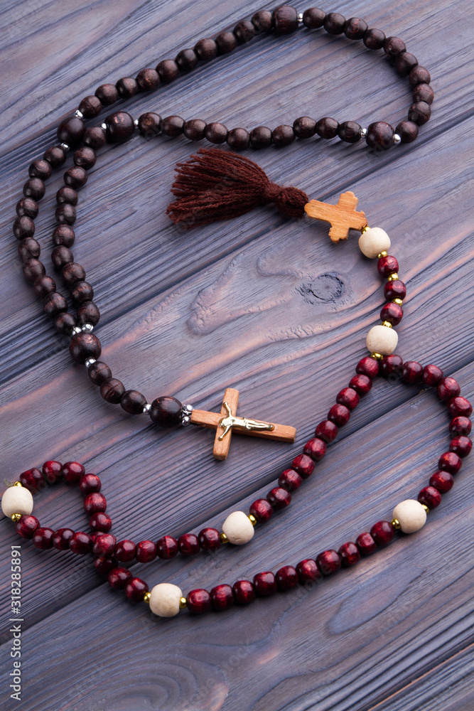 Brown and red rosaries on wood. Top view. Catholic roman attributes accessories, top view. Brown and red rosaries on wood. Top view. Catholic roman attributes accessories, top view.