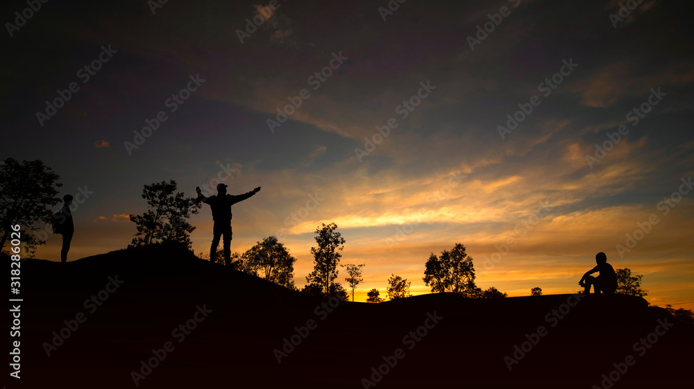 The silhouette of a person sitting and watching the sunset