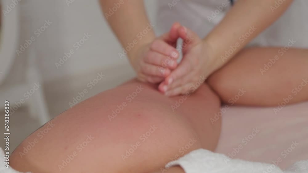 Female massage therapist doing massage over the entire length of the legs of a young girl. Female massage therapist doing massage over the entire length of the legs of a young girl.