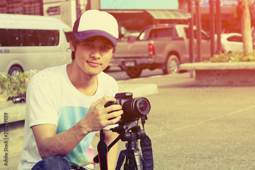 Handsome thai man photographer to pay close attention to take a photo, Traveler Lifestyle Concept, vintage style.