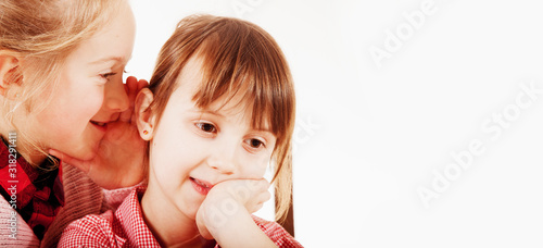 Foto Humorous portrait of two cute child girls gossiping and whispering each other secrets
