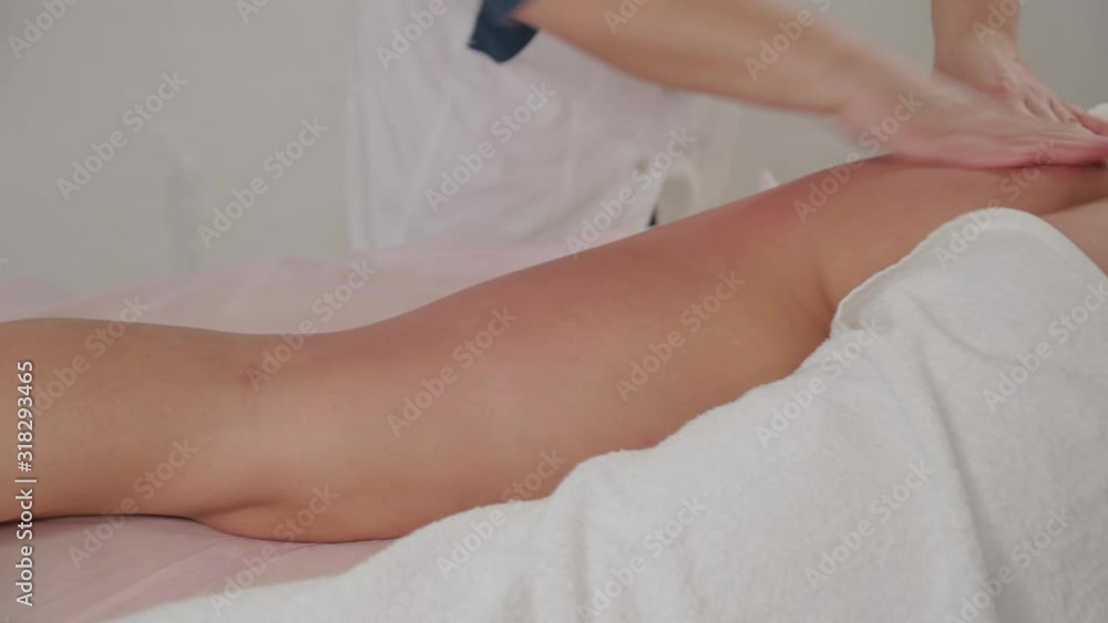 Woman massage therapist does massage on the legs of a young girl in a massage parlor. Woman massage therapist does massage on the legs of a young girl in a massage parlor.