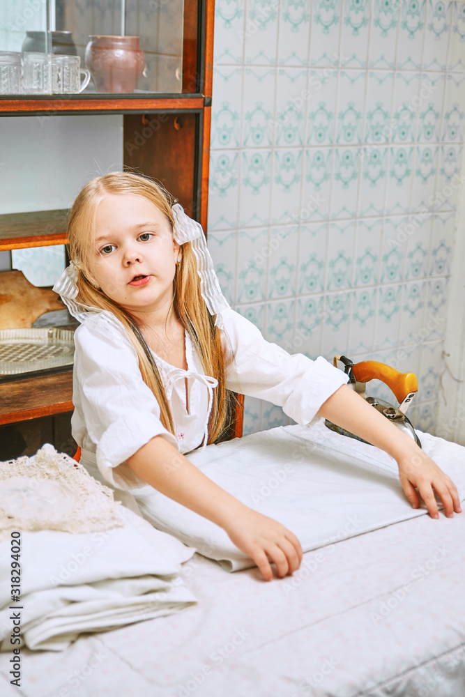 cute little girl ironing clothes in the kitchen. child assistant mistress cute little girl ironing clothes in the kitchen. child assistant mistress