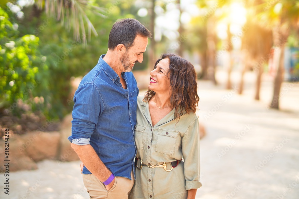 Middle age beautiful couple smiling happy and confident at town park. Standing with smile on face and hugging Middle age beautiful couple smiling happy and confident at town park. Standing with smile on face and hugging