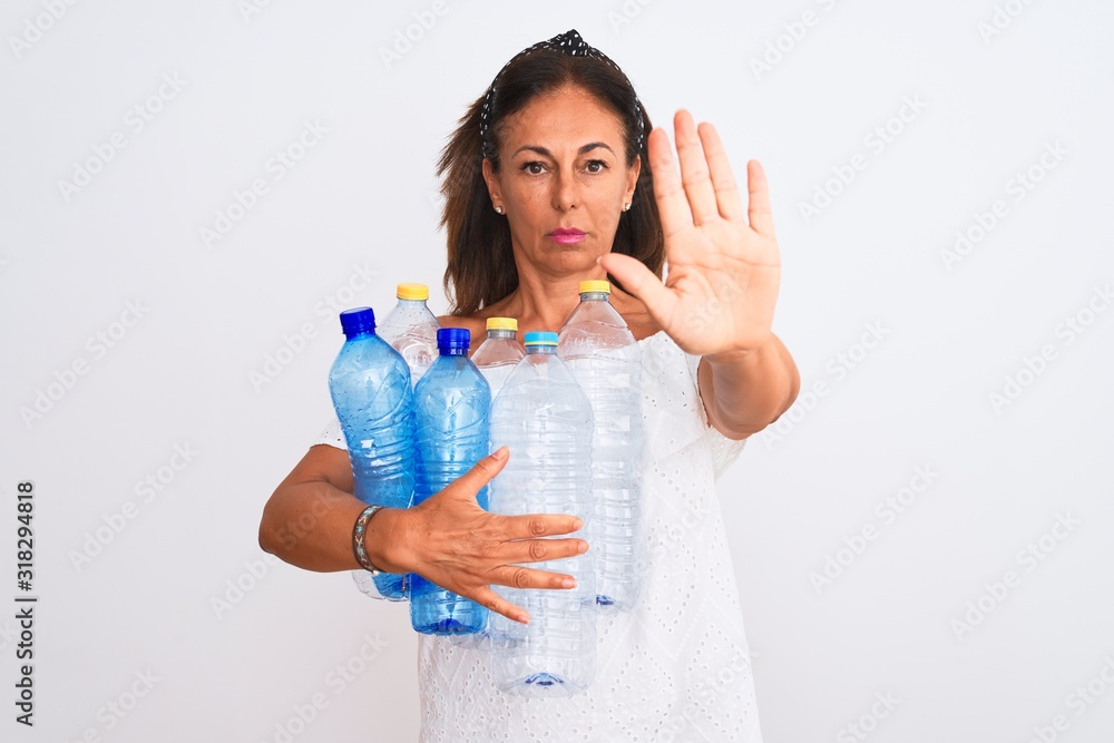 Middle age beautiful woman recycling plastic bottles standing over isolated white background with open hand doing stop sign with serious and confident expression, defense gesture Middle age beautiful woman recycling plastic bottles standing over isolated white background with open hand doing stop sign with serious and confident expression, defense gesture