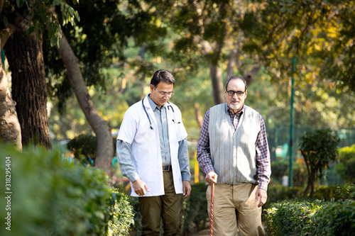 Doctor talking with senior man in hospital garden © creativeimages