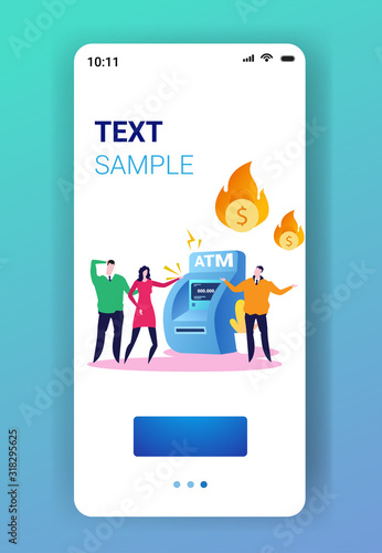 sad businesspeople near ATM machine with flaming dollar symbol financial crisis transaction denied locked bank credit card bankruptcy concept smartphone screen mobile app full length copy space vector