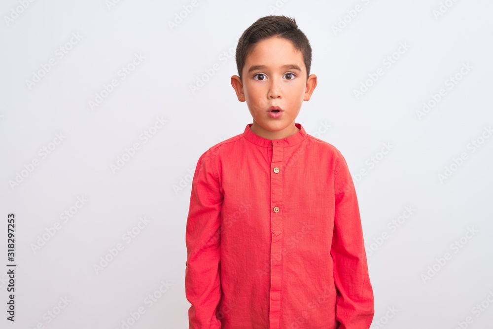 Beautiful kid boy wearing elegant red shirt standing over isolated white background afraid and shocked with surprise expression, fear and excited face. Beautiful kid boy wearing elegant red shirt standing over isolated white background afraid and shocked with surprise expression, fear and excited face.