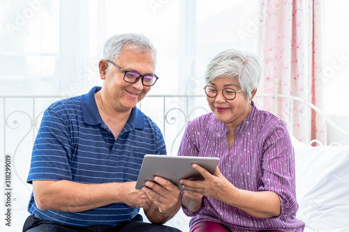 Senior couple man and woman holding and using digital tablet