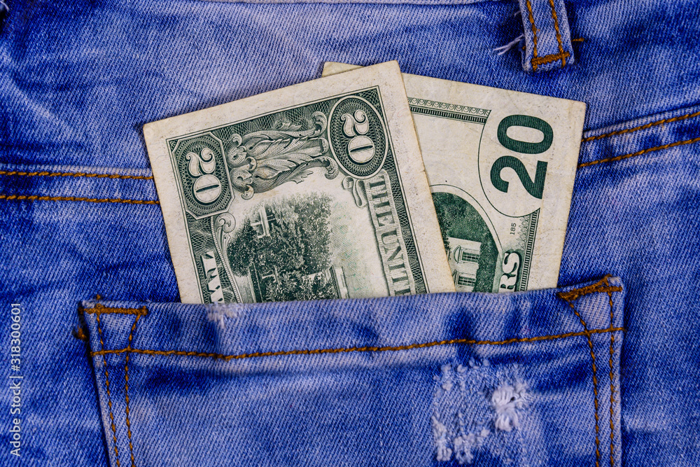American twenty dollar banknotes in a pocket of blue jeans American twenty dollar banknotes in a pocket of blue jeans