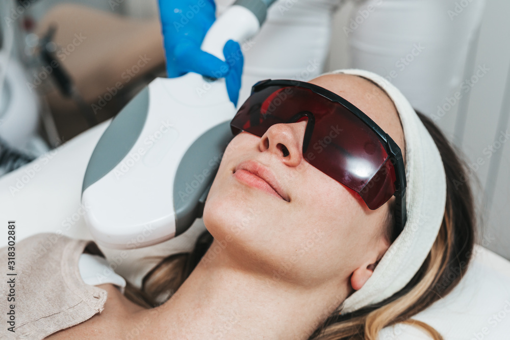 Beautiful young woman getting hair removal cosmetology procedure at cosmetic beauty spa clinic. Beautiful young woman getting hair removal cosmetology procedure at cosmetic beauty spa clinic.