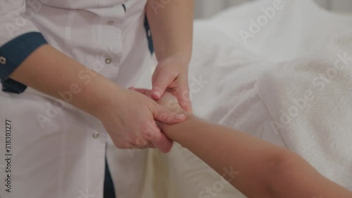 Wallpaper Mural Woman massage therapist doing massage on the whole arm to a young girl in a massage parlor. Torontodigital.ca