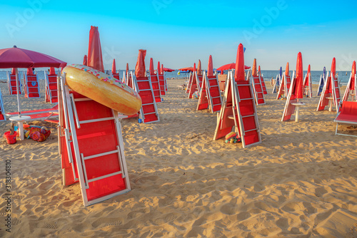 Beach chairs and umbrellas on beach. Travel destination Rovenna, Italy photo