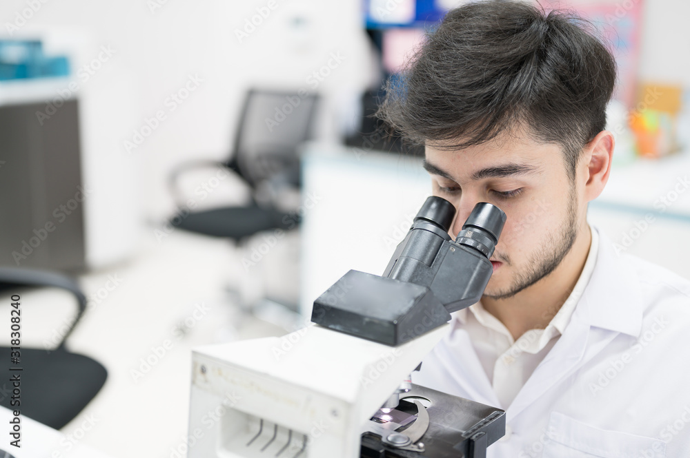 Portrait scientist man sitting and looking microscope in laboratory.Researcher using microscope in medical laboratory. Medical healthcare technology and pharmaceutical research concept. Portrait scientist man sitting and looking microscope in laboratory.Researcher using microscope in medical laboratory. Medical healthcare technology and pharmaceutical research concept.