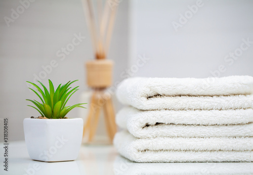 Cosmetic products and cotton towels on white wooden table in beauty salon