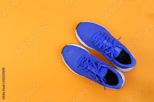 Foto Top view blue running shoes on orange pastel background